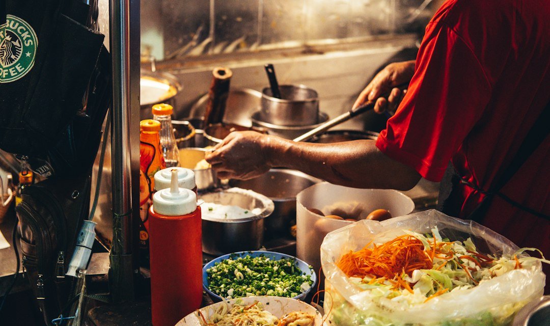 Street food vendor cooking with fresh ingredients at a Bangkok market stall