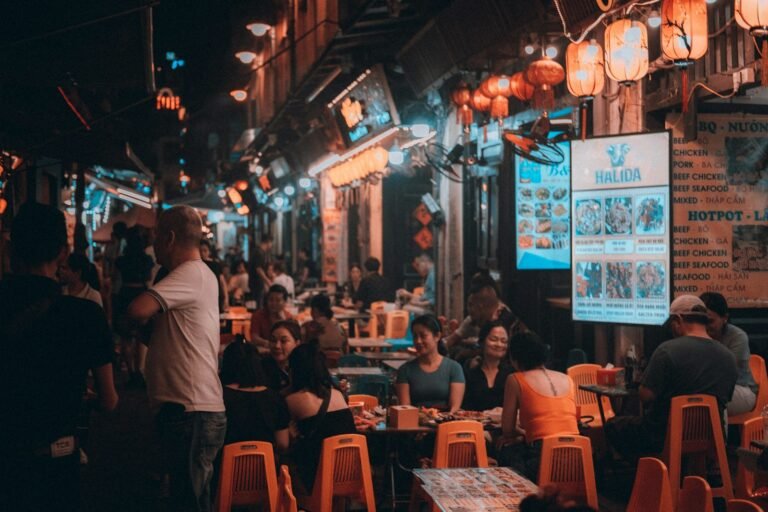Diners eating at small street-food tables in Hanoi at night