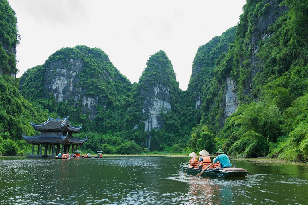 Boat traveling between limestone mountains in Ninh Binh, Vietnam